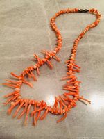 Full view of pink coral necklace showing the length and arrangement of coral branches and beads.