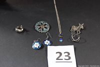All six jewelry pieces displayed on black surface with lot number 23.