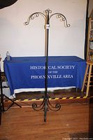 Front view of full coat rack showing three-legged curled base and curled hook arms at top, total height 74.5 inches, width 29 inches.