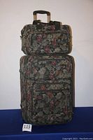 Two stacked floral patterned soft shell suitcases shown full height, illustrating size difference and luggage rack capability.