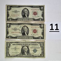 Three bills laid flat on white background: two $2 bills from Series 1953 and one $1 silver certificate Series 1957A.