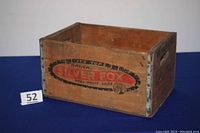 Front and side view showing wooden crate construction, metal reinforced edges, and branded text "Drink Silver Fox Real Fruit Soda".