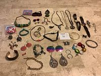 Overview of all jewelry pieces including 925 silver bracelet, watches, earrings, rings, necklaces, and bracelets arranged on marble surface.