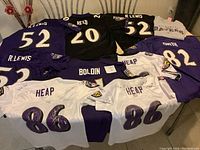 Nine youth Baltimore Ravens football jerseys and one T-shirt, some signed by players.