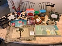 Overview showing palm tree placemats, picture frames, nail dryer, M&M figurines, small decorative items, mini Disney basketball, and packaged Calypso panels