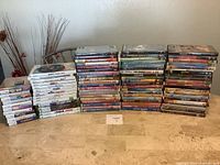 Full lot with DVDs, Nintendo Wii, Xbox 360 and Nintendo DS games in cases in columns on table