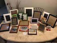 Wide view of assorted picture frames arranged on table showing variety of sizes and styles
