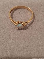 Top-down view of opal ring on grey felt background