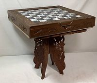 Full view of wooden carved chess table with drawers and ornate base