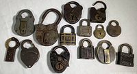 Overview of 13 antique brass and iron padlocks laid out