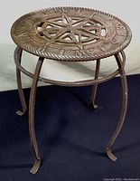 Side view of metal plant stand showing the curved legs and metal ring support