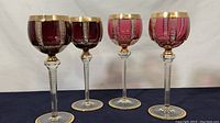 Four red crystal goblets in two shades arranged side by side