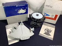 Davis Instruments plastic sextant next to Pelorus compass on gimbal, both with original boxes and instruction manuals.