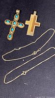 Two sterling silver cross pendants with distinct designs, two bracelets, and two silver chains including one broken chain.