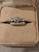 Rings set in beige suede box showing engagement ring and companion band stacked