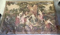Full view of the large tapestry spread out on floor showing biblical scene with multiple figures and trees.