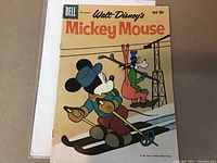 Front cover of the comic showing Mickey Mouse skiing with a guitar and Goofy in a ski lift chair, priced at 10 cents by Dell, marked March pre-March 1960.