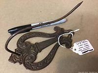Photo of antique Victorian cast iron wall hook showing detailed scrollwork and patina.