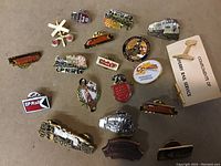 Photo showing 17 assorted metal lapel pins with railway and train themes, including miniature engines, CP Rail branding, a railway crossing sign, and commemorative designs.