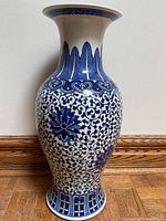 Full view of the blue and white porcelain vase showing floral patterns and shape.