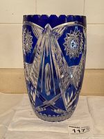 Front and side views showing the detailed blue and clear cut glass decoration with starburst pattern and geometric lines.