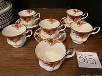 Group photo showing 3 Royal Albert Old Country Roses tea cups with ornate handles and matching saucers, all with gilded edges and floral rose decoration.