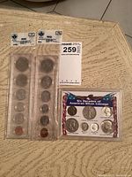 Photo showing two sealed 1968 US coin sets, lucite silver coin set and $2 bill block, plus coin price guides