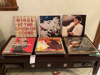 Front-facing display of six LP jacket covers on a wooden console