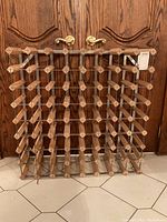 Front view of the wood wine rack showing the lattice design and multiple slots for bottles.