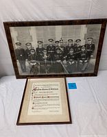 Full view of the framed group photo and framed citation side by side on white background.