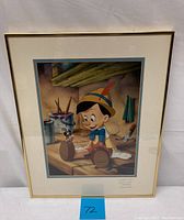 Framed lithograph of Pinocchio and Jiminy Cricket in a workshop setting.