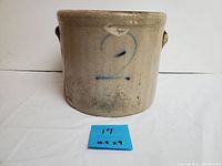 Front view of the beige stoneware crock with blue number 2 marking, showing size and wear.