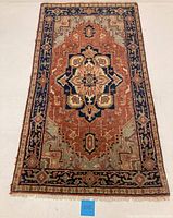 Full view of the rectangular vintage hand knotted Indo Hariz rug with geometric pattern and border.