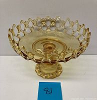 Side view of antique amber glass comport showing Doric Lace openwork edge and pedestal base.