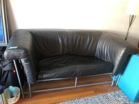 Front view of black leather two-seater sofa
