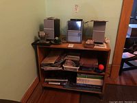 Photo showing Panasonic CD stereo system with two speakers on a wooden shelf unit. Also visible are assorted books and CDs on the shelves below.
