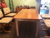 Front angle view showing the table surrounded by four chairs and the wood grain top surface.