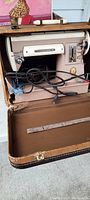 Full frontal view of the Singer Model 301-A sewing machine inside its original carrying case, showing pink/salmon machine and cords.