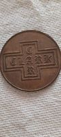 Clear photo of one side of a large bronze coin showing embossed cross and 'Clark' lettering.