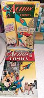Front view of two vintage Action Comics showing covers with Superman, one priced 15 cents, the other 20 cents, placed upright for display.