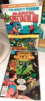 Photo showing the front covers of two vintage Marvel comic books: The Mighty Thor Marvel Spectacular and Super Villains.