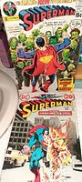 Photo showing 2 vintage Superman comic books including ones titled 'Superman of Earth' and 'The Man of Molten Steel'