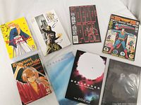 Photo showing multiple comic and graphic novel covers: Ranma 1/2, Iron Fist, Deadpool, Superman 100-page special, Rurouni Kenshin, and Descender editions.