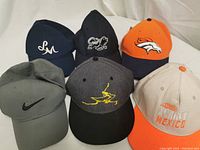 Six hats arranged in two rows showing logos and colors.