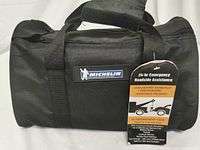 Closed Michelin branded emergency kit bag showing front logo and roadside assistance tag.