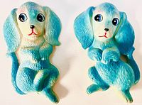 Top view of two matching ceramic dog figurines in blue and white with detailed textured fur and expressive eyes.