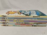 Side view showing the spines of six vintage children's books in the Bright & Early series including Dr. Seuss, Berenstain Bears, Rosetta Stone and Richard Scarry.