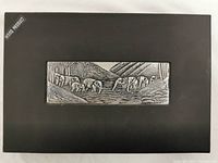 Black box with metal elephant art panel on lid, showing overall packaging of lot