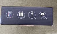 Photo of the product box showing side icons indicating remote control, battery operation, USB cable, and touch switch features.