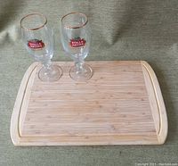 Bamboo cutting board with two Stella Artois glasses placed on top, showing size and appearance of items.